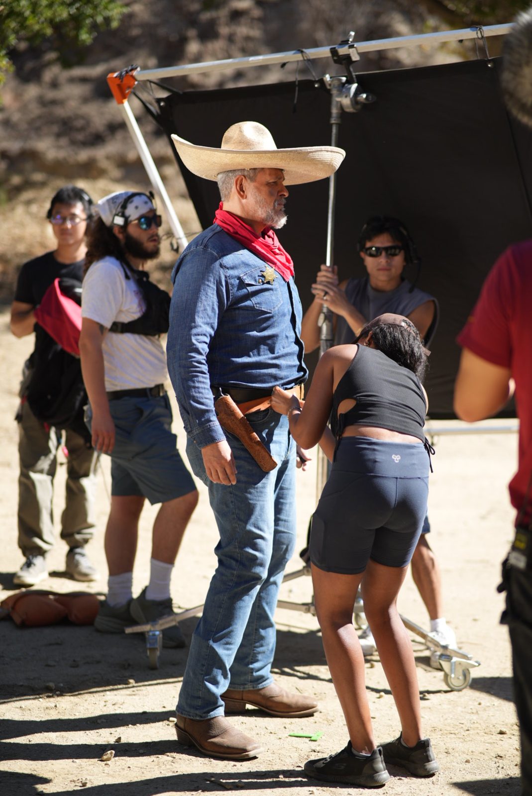 Young cast member in cowboy costume between setups